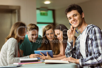 Smiling friends sitting studying and using tablet pc