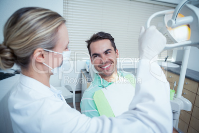 Female dentist examining mans teeth