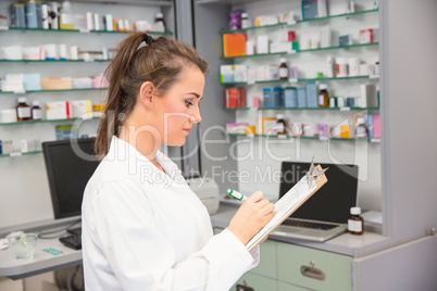 Pharmacy intern writing on clipboard