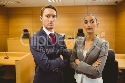 Unsmiling lawyers looking at camera crossed arms