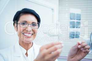Happy female dentist holding x-ray