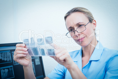 Female dentist looking at x-ray