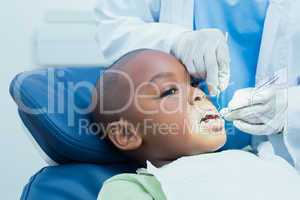 Boy having his teeth examined by dentist