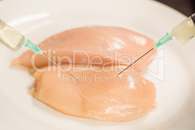 Food scientist injecting raw chicken