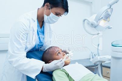 Female dentist examining boys teeth