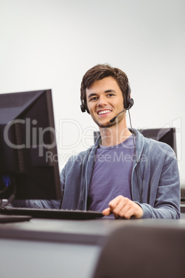 Student sitting at the computer room wearing headset