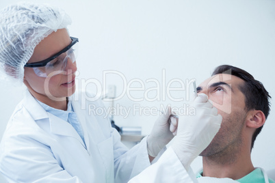 Female dentist examining mans teeth