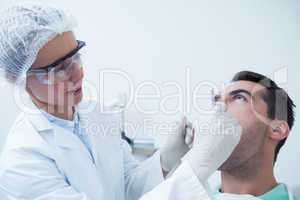 Female dentist examining mans teeth