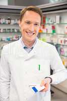 Happy pharmacist holding medicine boxes