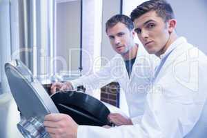 Two scientists opening the lid and looking at the camera