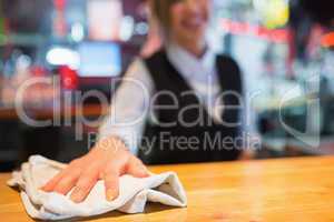 Pretty barmaid wiping down bar