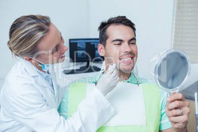 Female dentist examining mans teeth