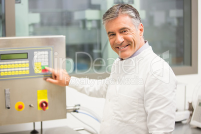 Senior pharmacist using machine to make medicine