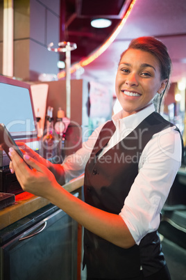 Pretty barmaid using touchscreen till