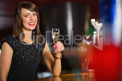 Pretty brunette drinking glass of champagne