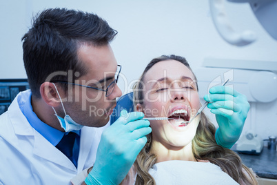 Dentist examining young womans teeth