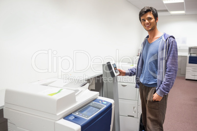 Smiling student standing next to the photocopier