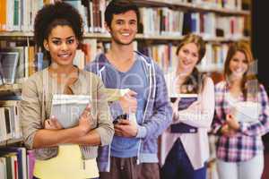 Happy students holding books in row