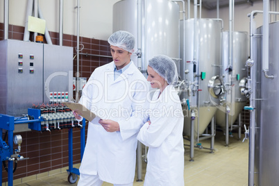 Scientist speaking to his colleague holding clipboard