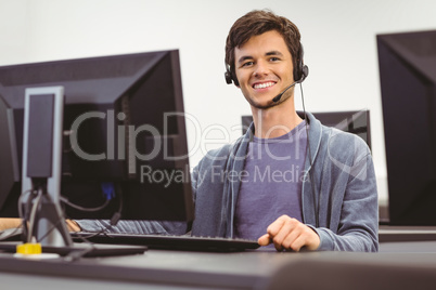 Student sitting at the computer room wearing headset