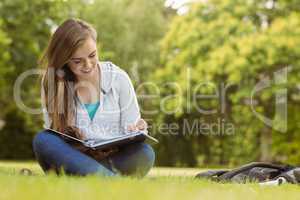 Smiling student sitting and reading book