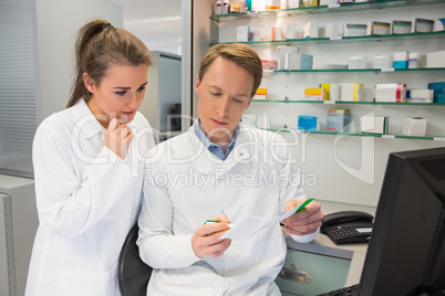 Team of pharmacists looking at prescription