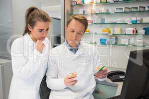 Team of pharmacists looking at prescription