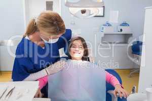 Pediatric dentist examining her smiling young patient