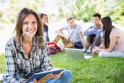 Happy students sitting outside on campus Happy students sitting outside on campus