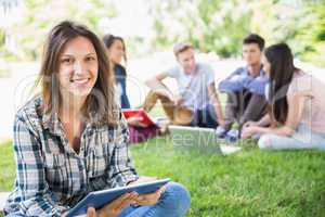 Happy students sitting outside on campus