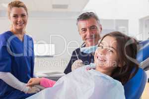 Smiling pediatric dentist and nurse with a young patient