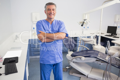 Happy dentist standing with arms crossed