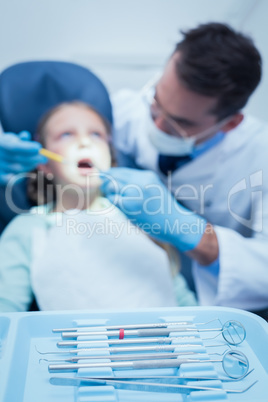 Male dentist examining girls teeth