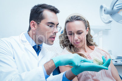 Male dentist showing woman prosthesis teeth