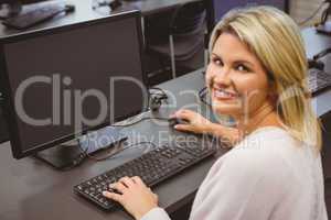Mature student in computer room smiling at camera