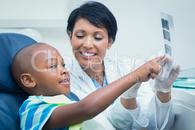 Female dentist showing boy his mouth x-ray