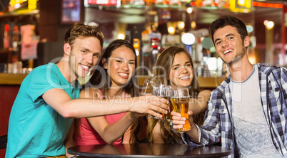 Portrait of happy friends toasting with drink and beer