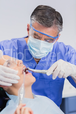 Dentist wearing surgical mask and safety glasses
