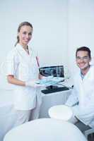 Portrait of smiling dentists with computer monitor