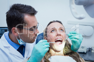 Dentist examining young womans teeth