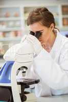 Young scientist working with microscope