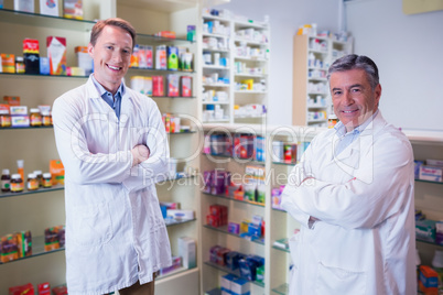 Smiling pharmacists standing with arms crossed