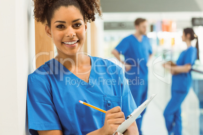 Medical student taking notes in hallway