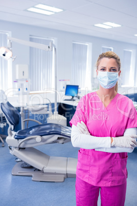 Dentist in pink scrubs standing with arms folded Dentist in pink scrubs standing with arms folded