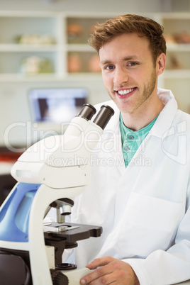 Young scientist working with microscope