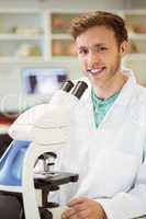 Young scientist working with microscope