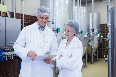 Scientist speaking to his colleague holding clipboard