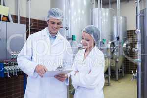 Scientist speaking to his colleague holding clipboard