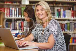 Smiling mature female students using her laptop