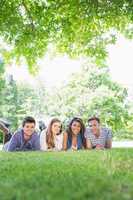 Happy students using laptop outside